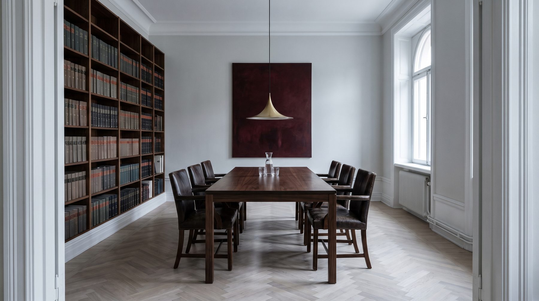 Mötesrummet på byrån, med bokhyllor och högt fönster